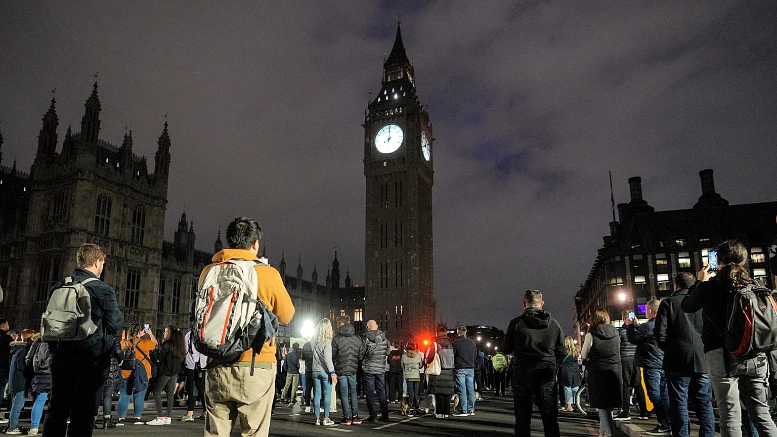 La gente guarda un minuto de silencio por la difunta reina Isabel II en el puente de Westminster frente al Big Ben en Londres, Reino Unido, 18/9/2022