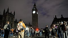 La gente guarda un minuto de silencio por la difunta reina Isabel II en el puente de Westminster frente al Big Ben en Londres, Reino Unido, 18/9/2022