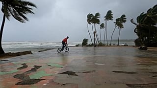 Un joven monta en bicicleta en la costa, mientras Fiona llega a República Dominicana