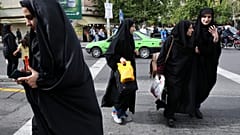 Iranian women wearing headscarves crossing a street in Tehran, Iran. Sunday, 22 April 2018.