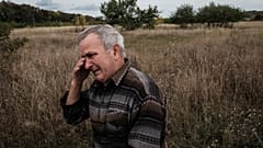 Valeriy Balandiuk, who returned home four days ago, cries after burying his dog that died during the Russian occupation, in the retaken town of Tsupivka, Kharkiv region