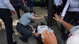 Специалист помогает женщине с приступом паники после эвакуации из-за землетрясения в Мехико