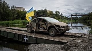 Ukrainian paratroopers drive on the vehicle with Ukrainian flag on the pontoon bridge across Siverskiy-Donets river in the recently retaken area of Izium, Ukraine, Wednesday,