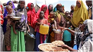 صورة من الارشيف-يتلقى صوماليون نازحون بسبب الجفاف، توزيعات غذائية في مخيمات مؤقتة في منطقة تابيلا في ضواحي مقديشو، الصومال