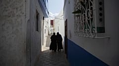 امرأتان تسيران في أزقة مدينة أصيلة، شمال المغرب