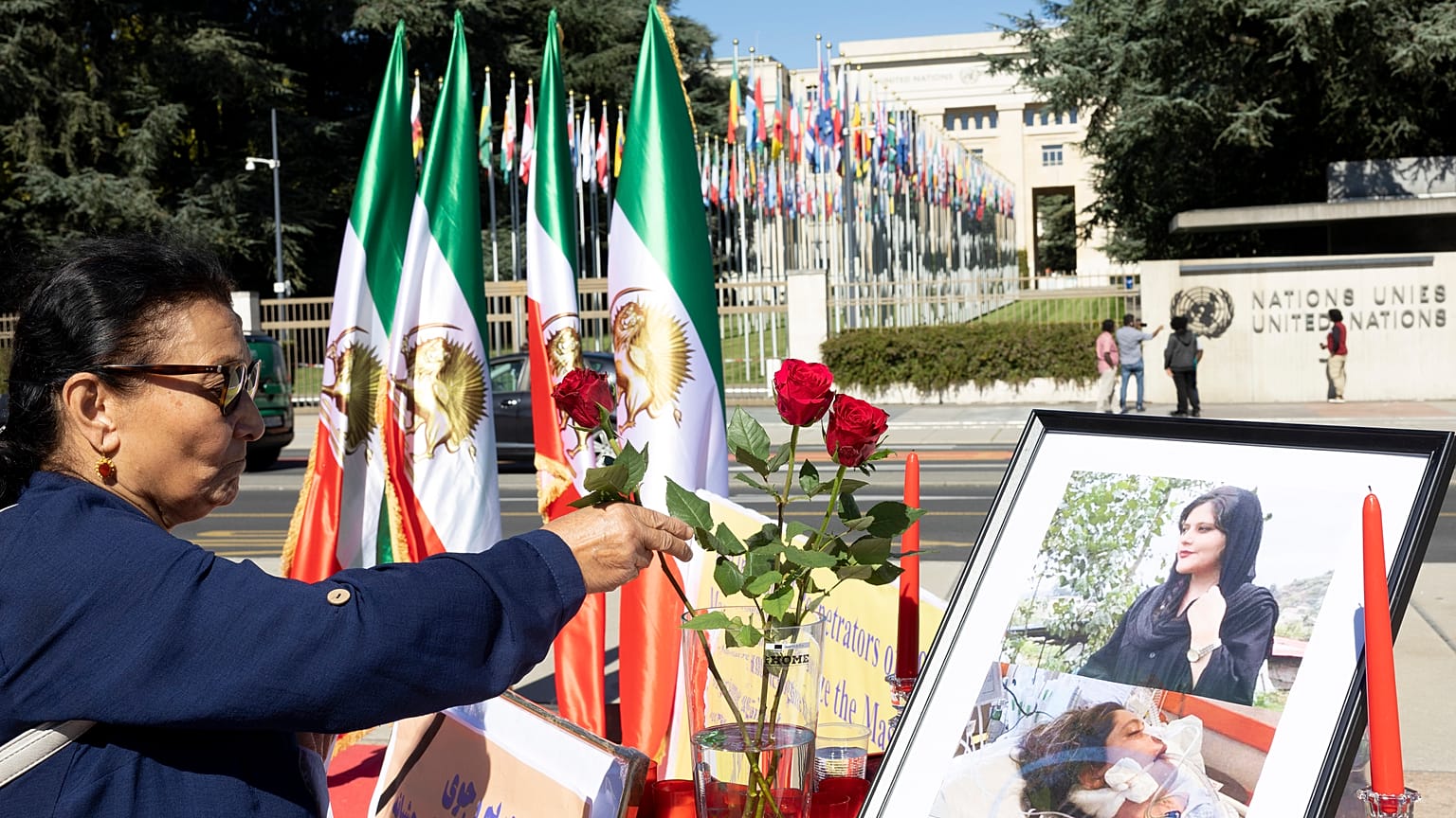 Una persona coloca una flor frente a un retrato de Mahsa Amini durante una manifestación de protesta frente a la sede europea de las Naciones Unidas en Ginebra, Suiza, 20/9/22