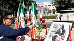 Eine Unbekannte stellt Blumen vor ein Foto der in Polizeigewahrsam gestorbenen Mahsa Amini, 20.09.2022