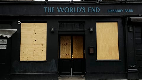 The World's End pub, which is a traditional place name for a boundary or the edge of an urban area, stands temporarily closed with boarded up windows due to Covid, 2020.  