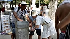 People cool off at a public fountain in a park in central Madrid during a heatwave, on August 2, 2022.