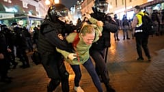 Eine Frau wird von Sicherheitskräften abgeführt