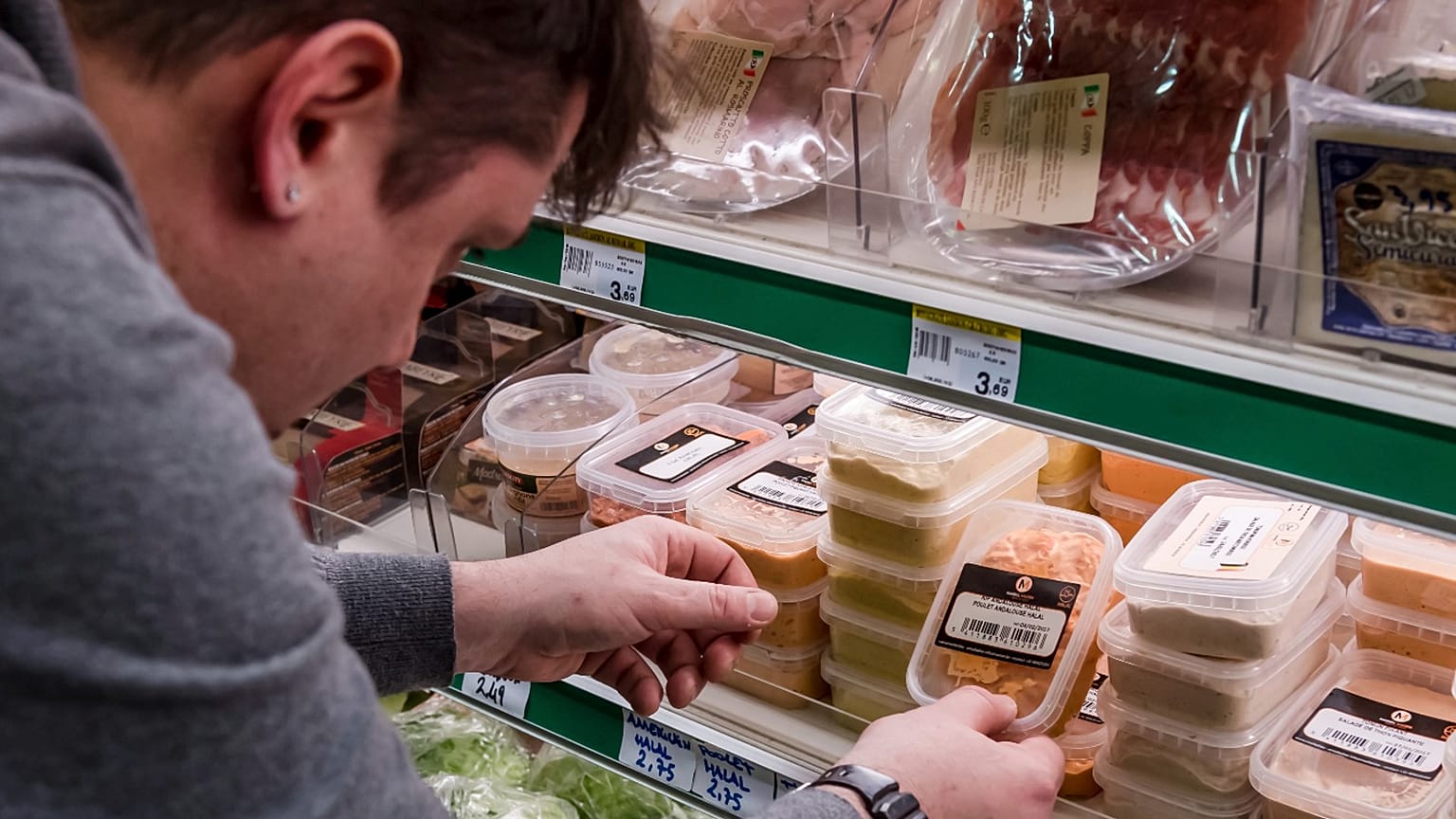 A worker removes expired food in a local supermarket in Brussels on Monday, Jan. 16, 2017.