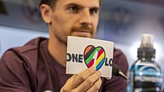 Le brassard est siglé d'un cœur rempli de six bandes parallèles et colorées, mais dont les couleurs diffèrent de celles du drapeau LGBT.