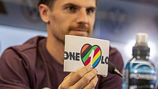 Le brassard est siglé d'un cœur rempli de six bandes parallèles et colorées, mais dont les couleurs diffèrent de celles du drapeau LGBT.