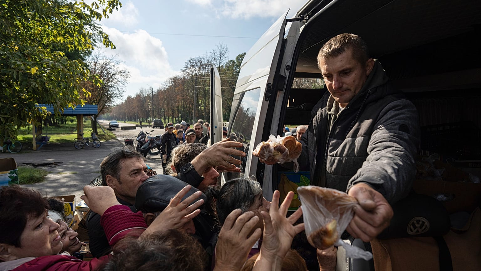 A volunteer distributes humanitarian aid to a local residents.