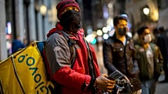 A Glovo food delivery courier stands next to Sol square in Madrid.