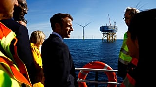 Le président français Emmanuel Macron discute avec des travailleurs à bord d'un bateau lors d'une visite au parc éolien offshore de Saint-Nazaire, 22/09/22