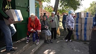 Vecinos de la aldea de Levyazhe hacen cola para recibir cajas con alimentos