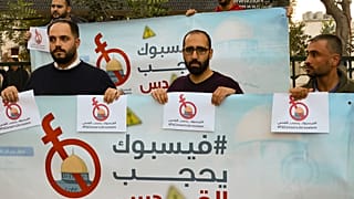 نشطاء وصحفيون فلسطينيون يحملون لافتات احتجاجا على رقابة فيسبوك للمحتوى الفلسطيني، في الخليل الضفة الغربية.