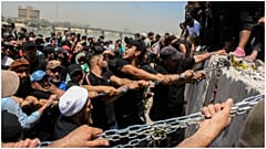 محتجون يحاولون اسقاط الكتل الخرسانية المحيطة بالمنطقة الخضراء وسط بغداد - 30/07/2022