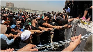 محتجون يحاولون اسقاط الكتل الخرسانية المحيطة بالمنطقة الخضراء وسط بغداد - 30/07/2022