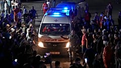 Red Cross ambulances carrying bodies of those died on a boat carrying migrants from Lebanon that sank in Syrian waters