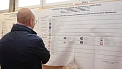 Ein Mann in Bologna betrachtet die Übersicht der antretenden Parteien