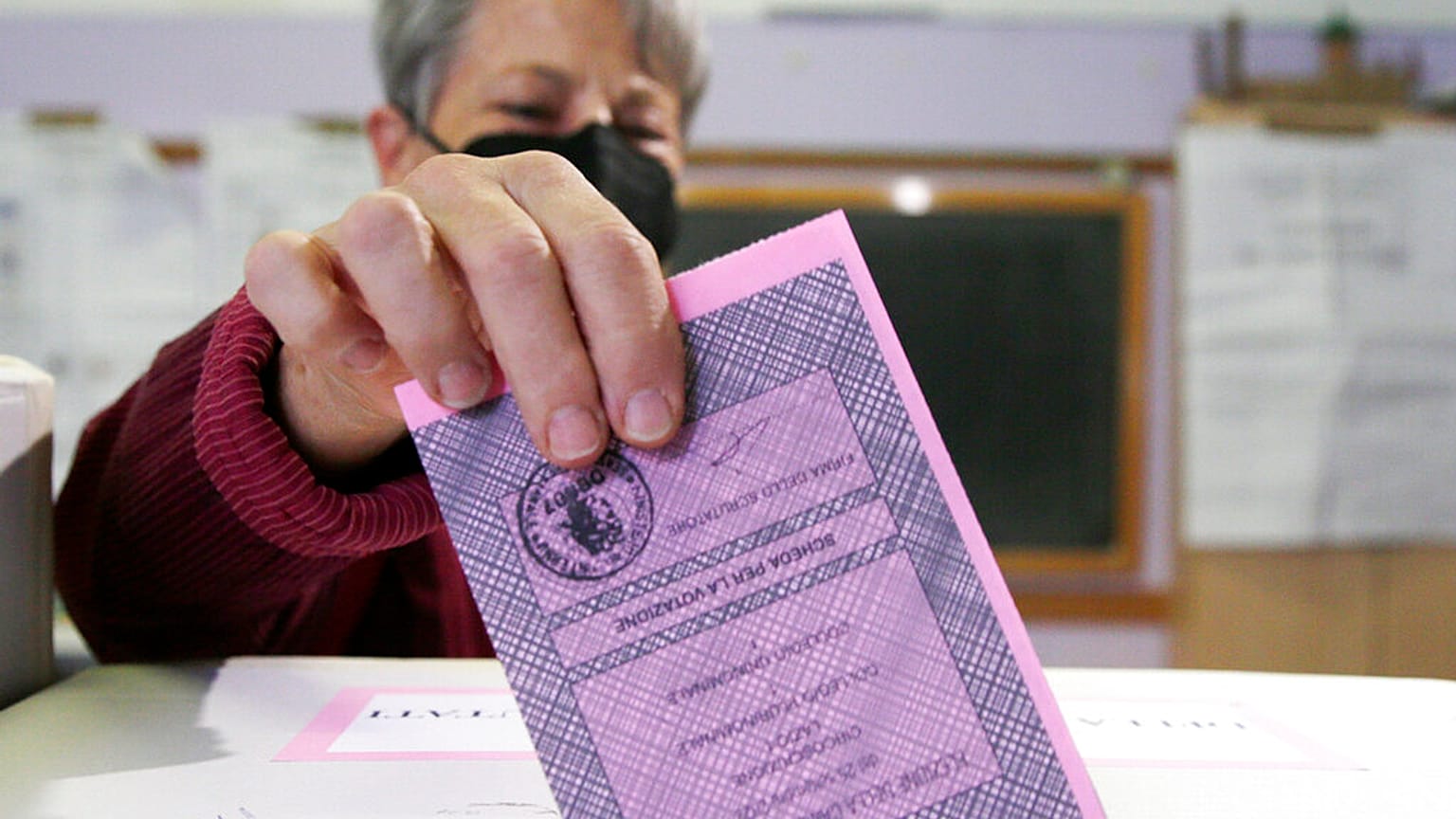 Una mujer deposita su voto en un colegio electoral de Roma