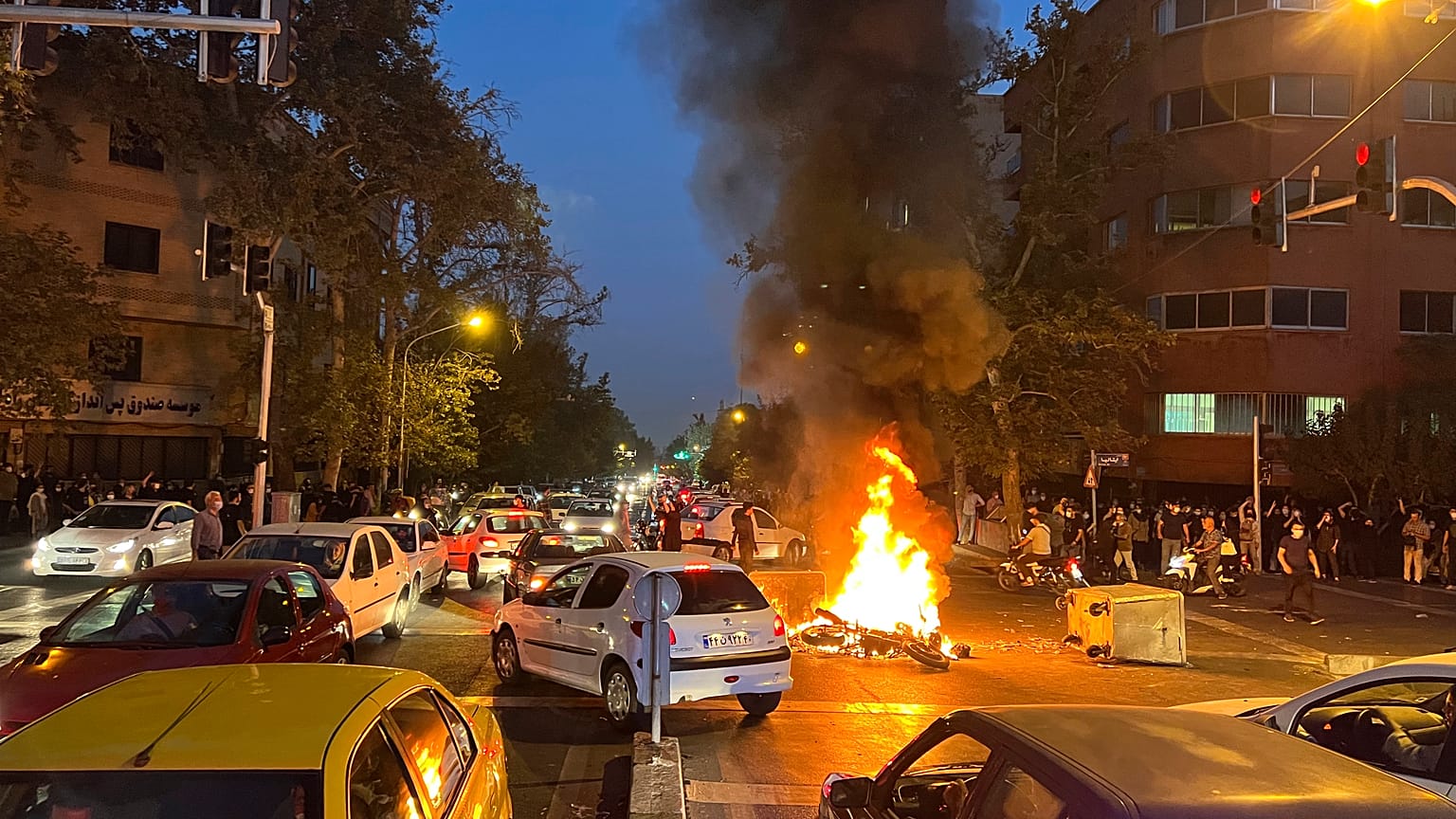 Протестующие сожгли полицейский мотоцикл в ходе выступлений в Тегеране 25 сентября 2022