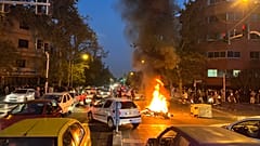 Протестующие сожгли полицейский мотоцикл в ходе выступлений в Тегеране 25 сентября 2022