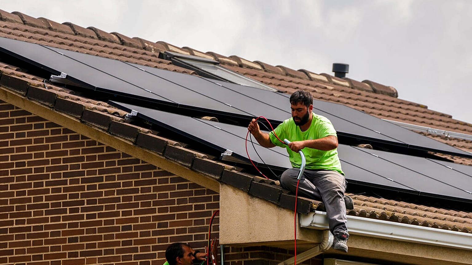 Un instalador coloca una placa solar en una casa de Madrid, España