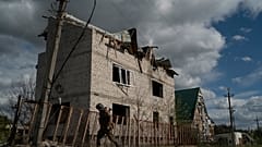 A Ukrainian serviceman from Dnipro-1 regiment walks past a damaged building in the retaken village of Shchurove.
