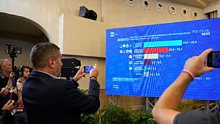 Journalists look at first result projections in a hotel where far-right party Brothers of Italy is waiting for the vote outcome in Rome, Sunday, Sept. 25, 2022.