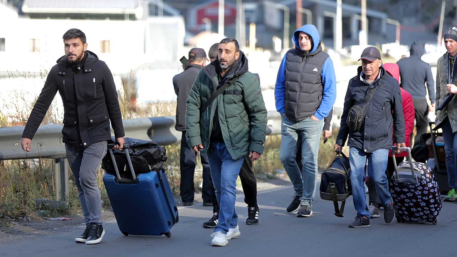 A group of Russians walk after crossing the border at Verkhny Lars between Georgia and Russia in Georgia, Tuesday, Sept. 27, 2022.