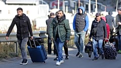 A group of Russians walk after crossing the border at Verkhny Lars between Georgia and Russia in Georgia, Tuesday, Sept. 27, 2022.