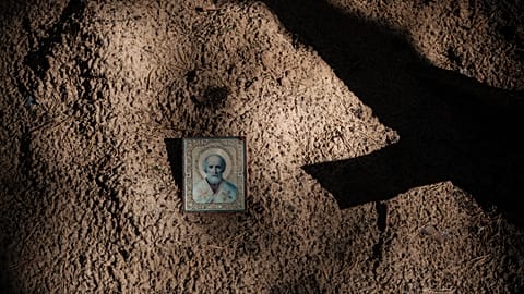 Icône sur le sol entre des tombes vides après l'exhumation de corps dans une fosse commune découverte à Izyum en Ukraine après l'invasion russe - 25.09.2022