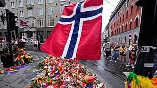 A Norwegian national flag flutters over flowers and rainbow flags near the London Pub in Oslo.