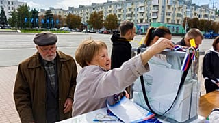 Une femme déposant son bulletin de vote lors d'un référendum à Lougansk, samedi 24 septembre 2022.
