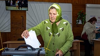 Eine Frau wirft in Luhansk einen Wahlzettel in eine Urne
