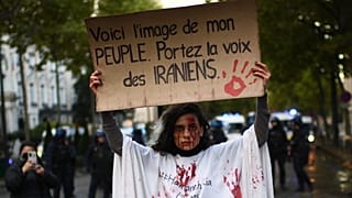Une manifestante tient une pancarte sur laquelle il est écrit : "Ceci est l'image de mon peuple. Portez la voix des Iraniens' - Paris, le 25 septembre 2022