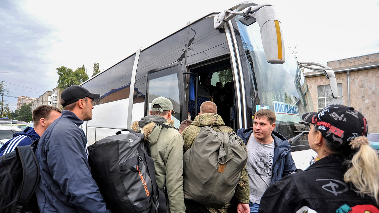 Hadkötelezettség alá vont orosz férfiak különbuszra szállnak egy sorozóirodánál az ukrán határnál levő Rosztov megyei Batajszkban 2022. szeptember 26-án.