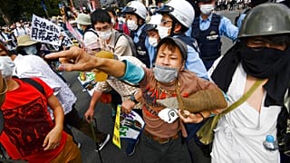 La police encercle des manifestants venus protester contre la tenue de funérailles nationales pour l'ex-premier ministre Shinzo Abe