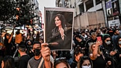Amini'nin resmini taşıyan protestocu