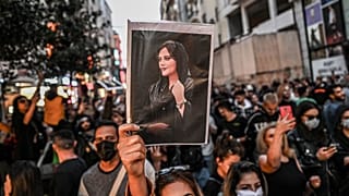 Amini'nin resmini taşıyan protestocu