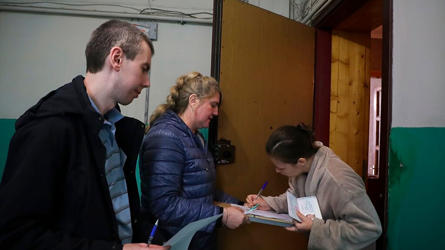 Nő szavaz a donyecki "népszavazáson" a választási biztosok viszla tekintete előtt