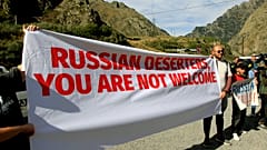 Акция протеста на границе с Россией. Плакат с надписью "Российские дезертиры, вам здесь не рады"