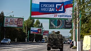 A military vehicle drives along a street with a billboard that reads: "With Russia forever, September 27", prior to a referendum in Luhansk, Ukraine on Sept. 22, 2022