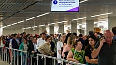 Amsterdam Schiphol Havaalanı'nda güvenlik kontrolünü geçmek için kuyrukta bekleyen yolcular 