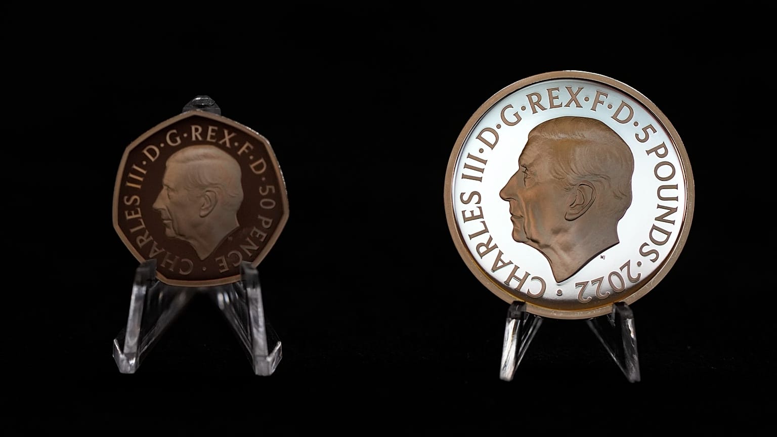 Les nouvelle pièces à l’effigie de Charles III, celle de 50 pence ( à gauche) et celle commémorative de 5 livres (à droite), lors de leur présentation le 29/9/2022 à Londres
