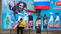 Eine Frau wartet an einer Bushaltestelle im russisch-besetzten Luhansk in der Ost-Ukraine am Tag nach dem dortigen Schein-Referendum