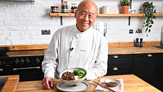 Ken Hom posing with a dish
